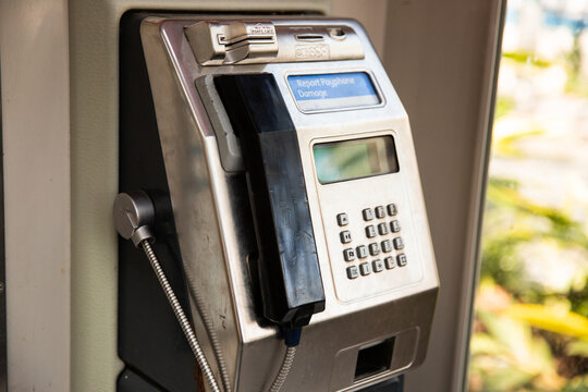 an old metal public payphone with black plastic receiver