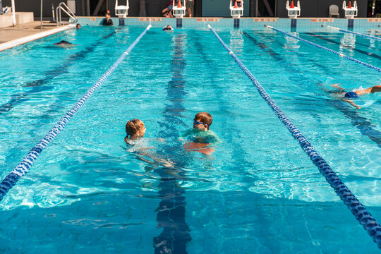 kids swimming in a public pool in the sunshine