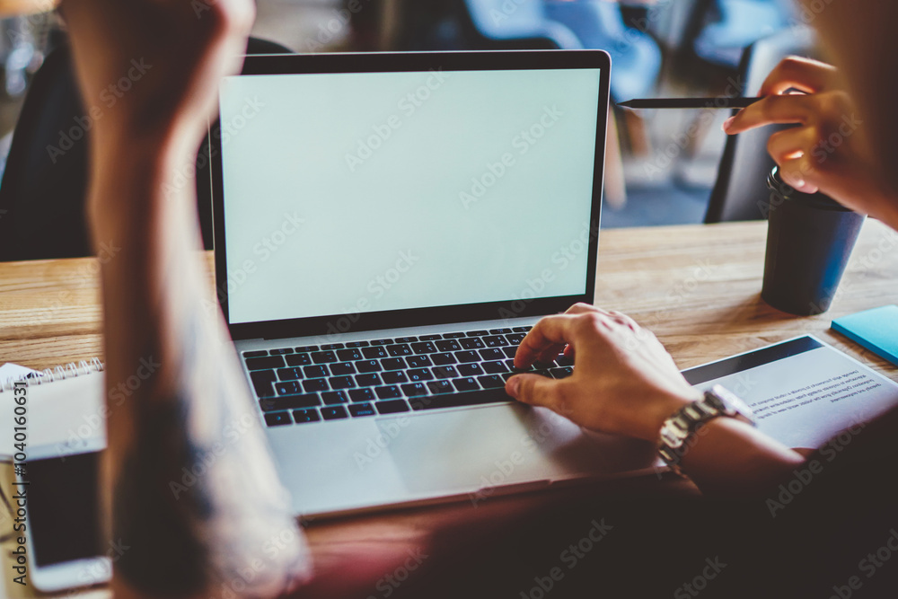Poster cropped back view of young man sitting at desktop with laptop device with copy space area for your i
