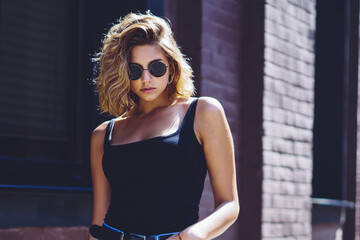 Half length portrait of arrogant female caucasian model dressed in denim jeans posing on publicity...