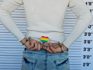 Girl handcuffed, holding LGBT flag