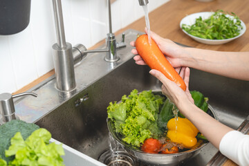 people washing raw vegetables at sink in the kitchen prepare ingredient for cooking