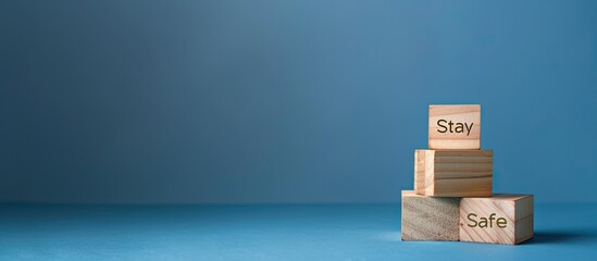 Wooden blocks with Stay Safe symbol on a stunning blue backdrop conveying a business and safety concept with ample copy space image