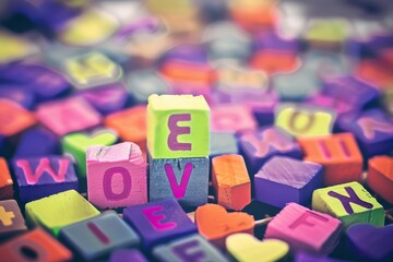Colorful blocks spell out love amidst a vibrant array of playful letters, creating a whimsical celebration of affection and joy