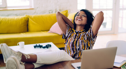 Smiling black student relaxing after working on laptop