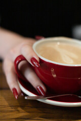 Cup of coffee and red nails