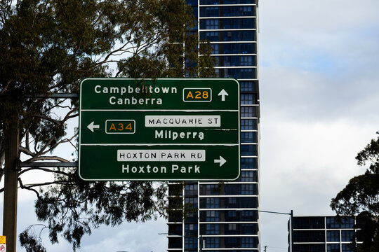 green roadside sign in Sydney pointing to Campbelltown A28 and A34 Milperra in city
