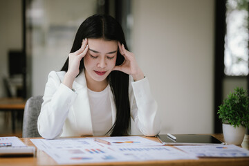 Asian businesswoman stressed about her projects, planning and thinking of new strategies at the office.