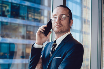 Half length portrait of confident economist dressed in formal suit looking at camera during...