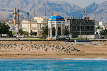 Coastal view of Sur Oman showcasing a traditional gazebo and picturesque mountains against a clear sky