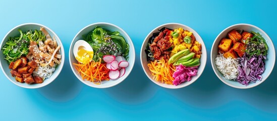 Various poke bowl variations displayed in a top view on a blue background with copy space image