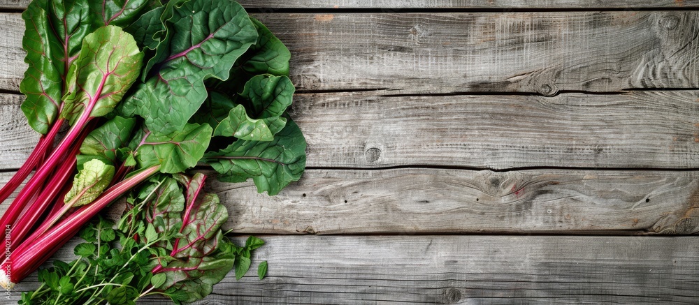 Poster top view of stem vegetables such as chard and beta vulgaris set on an herb stalk on a wooden backgro