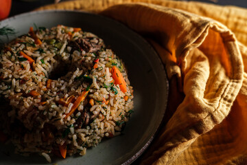 Spanish rice, uzbek pilaf hot dish with meat and vegetables, rustic table kitchen decoration with...