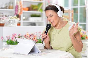 Beautiful young girl singing karaoke at home