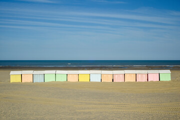 Beach huts in a row they are colourful in pastel shades on the sand