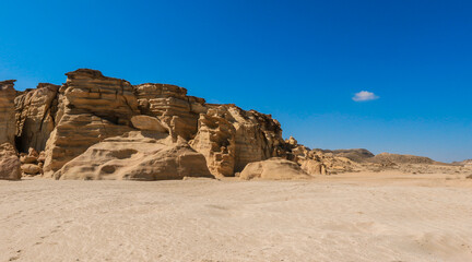 Turtle Beach in Oman showing unique rock formations and sandy shores under a clear blue sky during daylight