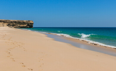 Enjoying a serene day at Turtle Beach in Oman with gentle waves and golden sands under a clear blue sky