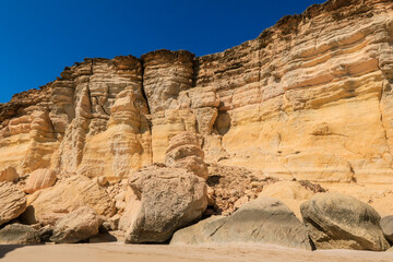 Obraz premium Exploring the stunning cliffs and sandy shores of Turtle Beach in Oman under a clear blue sky