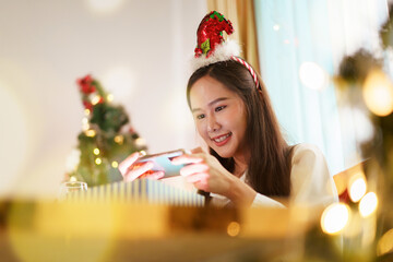 Beautiful Asian woman celebrating Christmas festival at home.