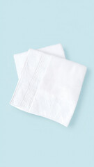 A pair of folded white napkins on a light blue background, ideal for dining and event decoration.