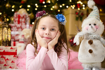 A little girl lies in the living room near the Christmas tree , New Year's magic