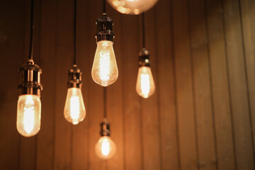 Dark, moody and dusty light bulbs with rough wall background.