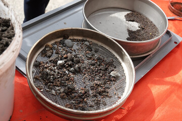 objects illustrating the process of archaeological excavations, bucket and sieves with soil