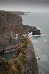 View of rugged cliffs and sea on a cloudy day. Pembrokeshire Coast National Park, Wales