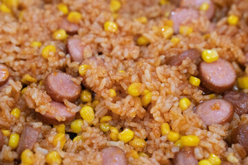 Delicious and easy to prepare homemade dish. Fried rice with corn and chopped sausages in tomato sauce or ketchup. Cooking tasty food