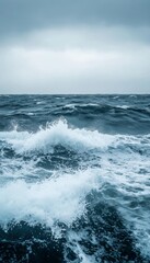 Rough seas churn under a stormy sky, the waves crashing and frothing in the wind.
