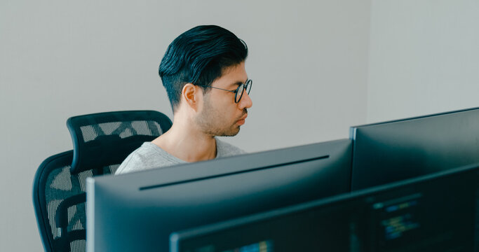 Young adult Asia male freelance eyeglasses typing write prompt AI bot IT app smart program nomad, video game, terminal with coding, user interface, designer, big data center on desktop computer.
