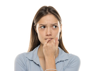 Fototapeta premium Unsure young woman biting her fingernails