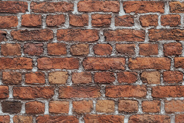 Closeup and detail of an old, weathered wall with reclaimed bricks in irregular patterns