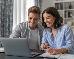 Obraz premium Young couple of new homeowners using laptop while doing their taxes.