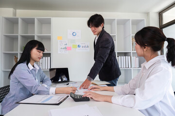 Obraz premium Young Business Team Collaborating on Marketing Strategy in Modern Office Setting with Charts and Graphs