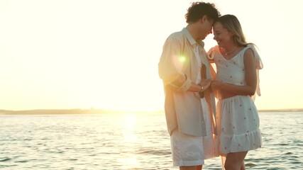 Smiling beautiful woman and her handsome boyfriend. Woman in casual summer clothes. Happy cheerful family. Female having fun. Couple posing in the street at sunset. embracing each other at beach