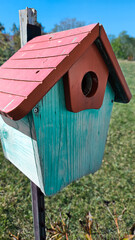adorable colorful birdhouse on stand in yard