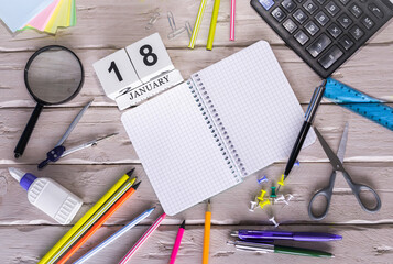 January calendar with number. Copy of space note  18. Top view of blank notepad. Space for text in a checkered sheet, stationery background with accessories.