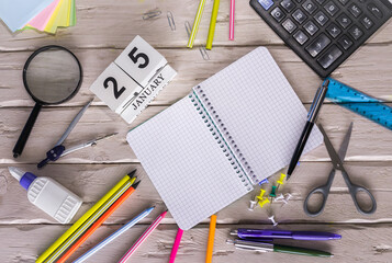 January calendar with number. Copy of space note  25. Top view of blank notepad. Space for text in a checkered sheet, stationery background with accessories.