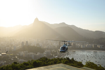 view from the sugar loaf over Rio de Janeiro in Brazil during sunset with a tourism helicopter taking off © Felipe