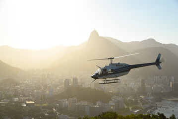 view from the sugar loaf over Rio de Janeiro in Brazil during sunset with a tourism helicopter...