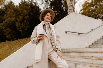 Fototapeta premium pretty smiling woman walking in park in autumn clothes