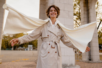 pretty smiling woman walking in park in winter clothes