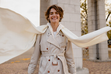 pretty smiling woman walking in park in winter clothes