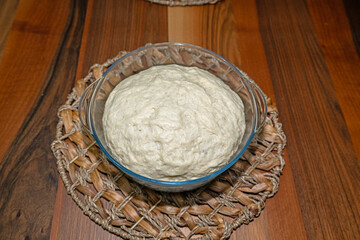 Kneaded and fermented dough in a bowl.