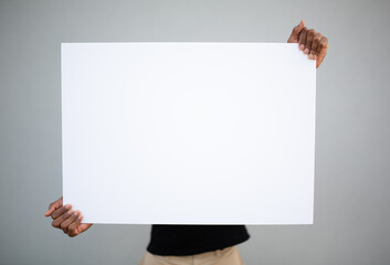 Man holding large white blank poster centered against gray background