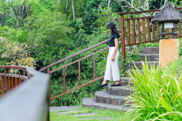 Fototapeta premium Woman Walking Up a Scenic Stone Staircase