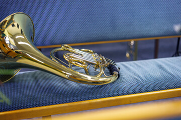 A trumpet on a bench in a brass band.