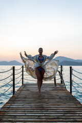 Fototapeta premium A stunning bikini model confidently posing on a pristine beach, showcasing the beauty of the coastline with a vibrant summer vibe. 