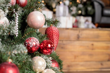 Festive fir tree branches with shiny red and white baubles, balls,snowy red berries, xmas ornaments. winter holidays. luxury